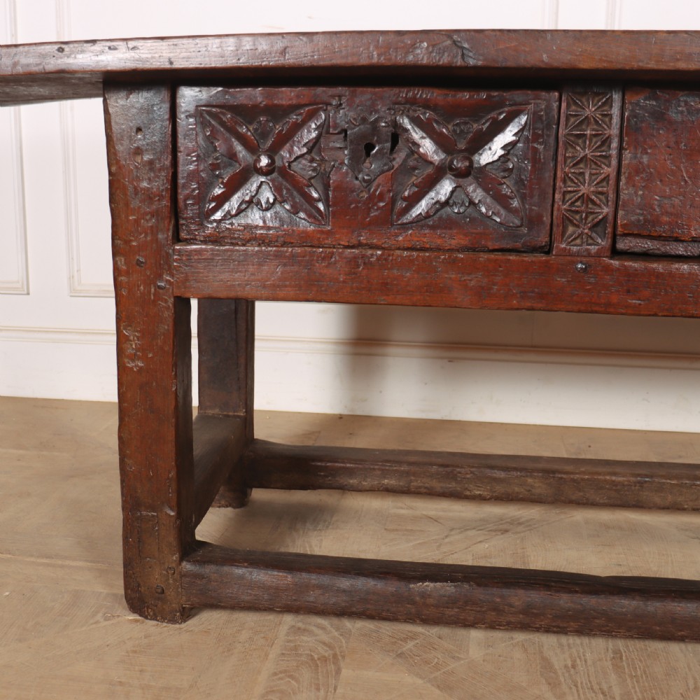 A 17th-century Spanish dark oak console table featuring a thick rectangular top over three geometric carved drawers, supported by sturdy legs with a perimeter stretcher. View VI