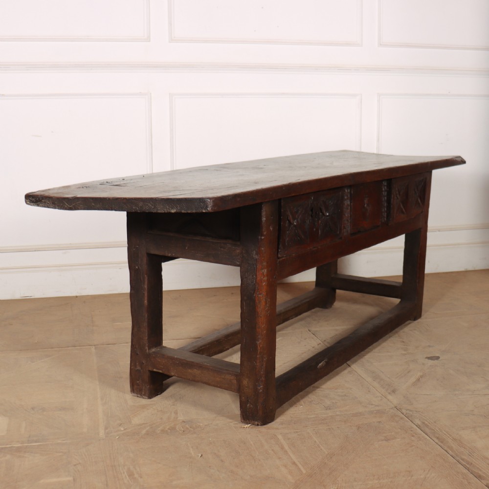 A 17th-century Spanish dark oak console table featuring a thick rectangular top over three geometric carved drawers, supported by sturdy legs with a perimeter stretcher. View VII