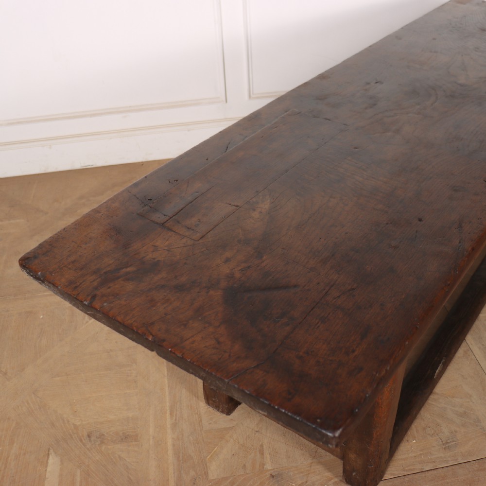 A 17th-century Spanish dark oak console table featuring a thick rectangular top over three geometric carved drawers, supported by sturdy legs with a perimeter stretcher. View VIII
