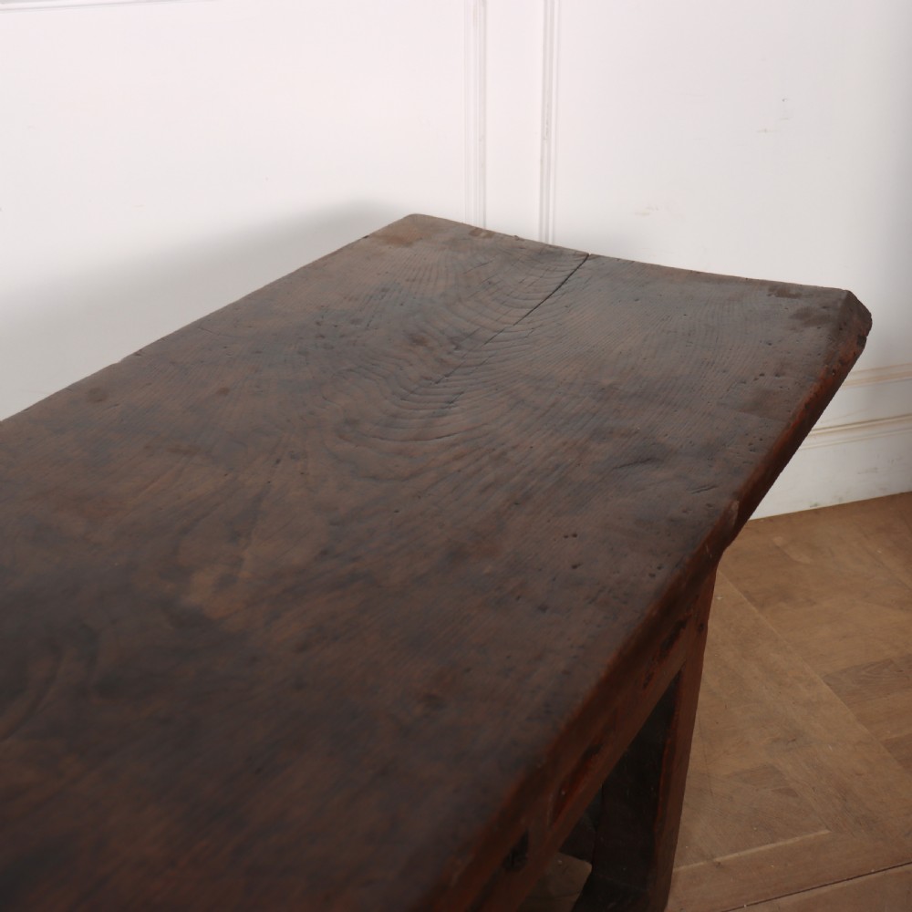A 17th-century Spanish dark oak console table featuring a thick rectangular top over three geometric carved drawers, supported by sturdy legs with a perimeter stretcher. View IX