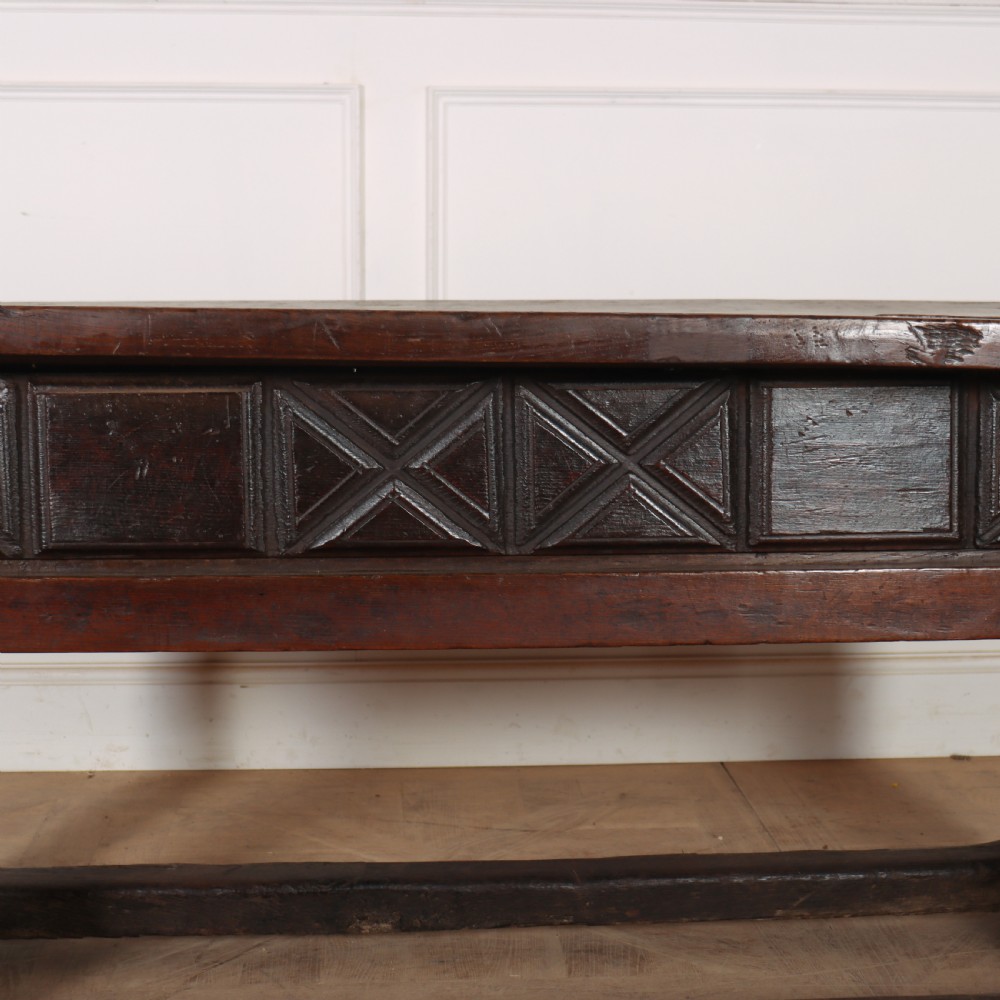A 17th-century Spanish dark oak console table featuring a thick rectangular top over three geometric carved drawers, supported by sturdy legs with a perimeter stretcher. View XIII