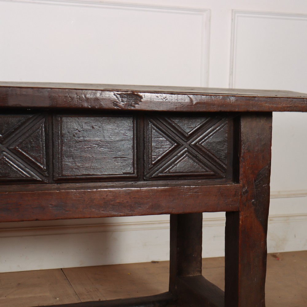 A 17th-century Spanish dark oak console table featuring a thick rectangular top over three geometric carved drawers, supported by sturdy legs with a perimeter stretcher. View XIV