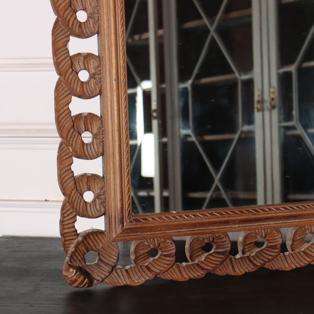 A rectangular wall mirror featuring an intricate hand-carved pine frame with an openwork twist pattern and warm wood finish. View V