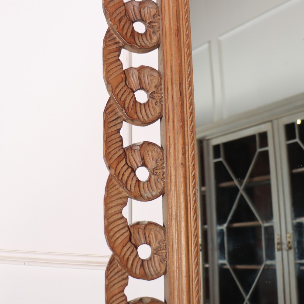A rectangular wall mirror featuring an intricate hand-carved pine frame with an openwork twist pattern and warm wood finish. View VI