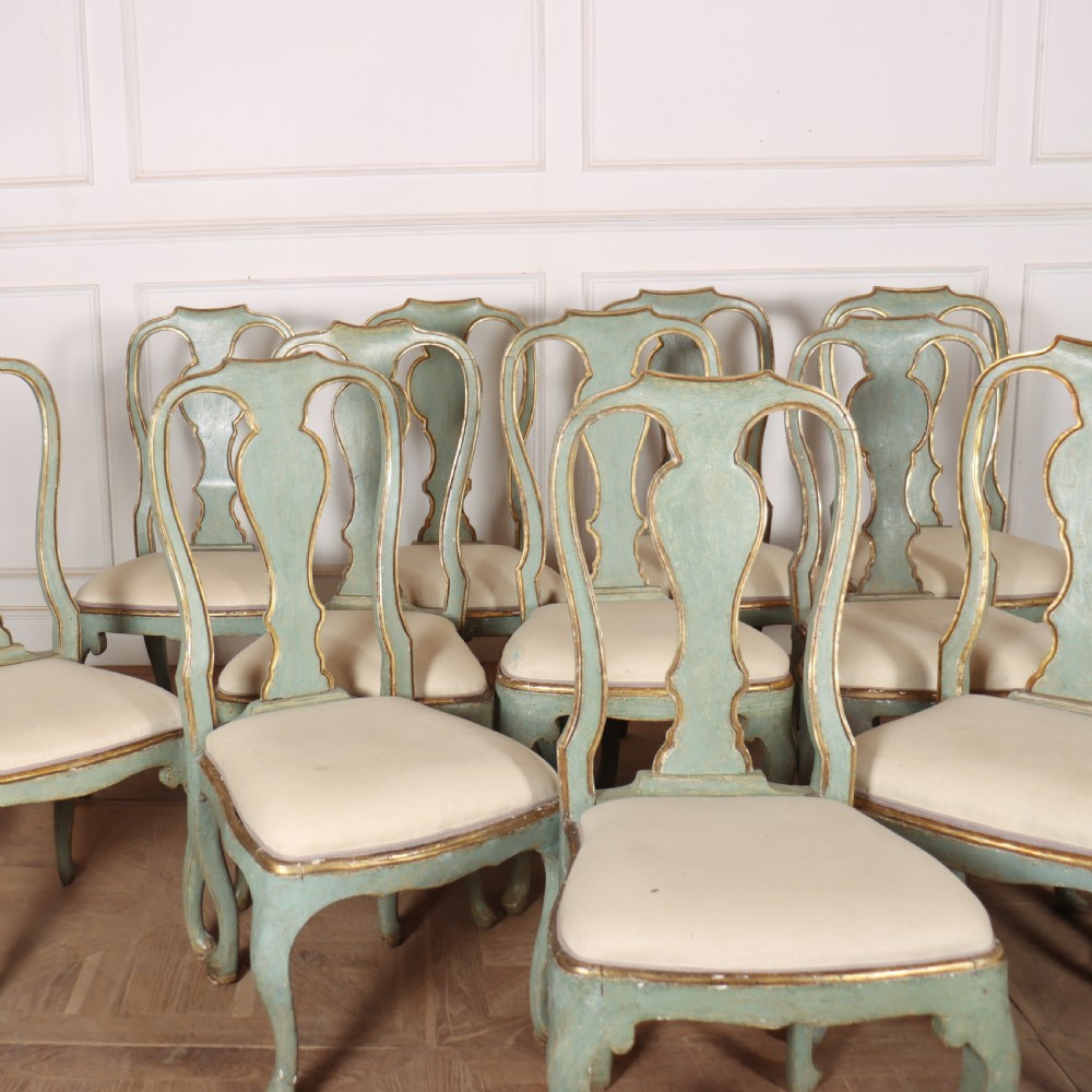 A set of twelve 18th-century Italian Rococo side chairs with pale green painted frames, parcel-gilt detailing, and cream upholstered seats. View III
