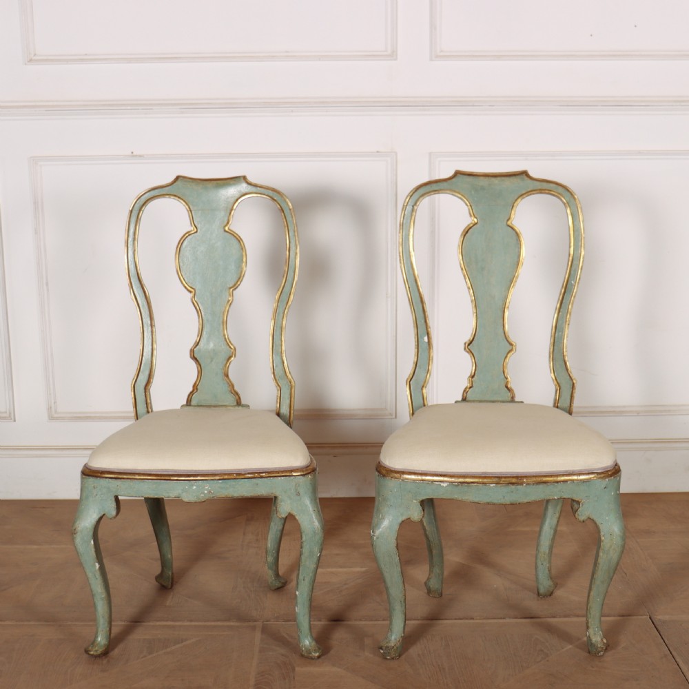 A set of twelve 18th-century Italian Rococo side chairs with pale green painted frames, parcel-gilt detailing, and cream upholstered seats. View VII