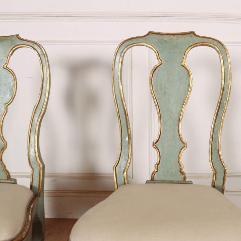 A set of twelve 18th-century Italian Rococo side chairs with pale green painted frames, parcel-gilt detailing, and cream upholstered seats. View IX