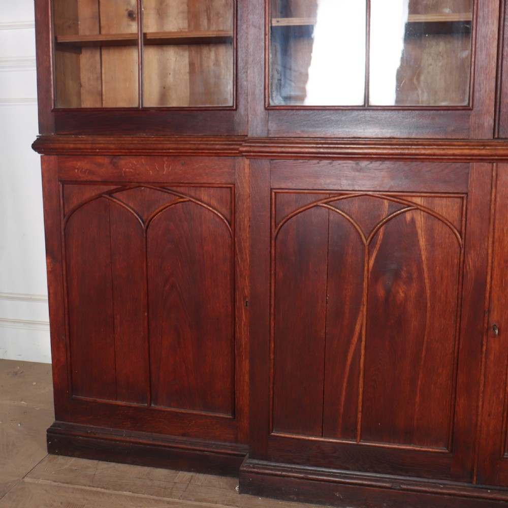 An early 19th-century mahogany breakfront bookcase featuring four glazed doors with Gothic pointed arch tracery over four matching panelled base doors. View II