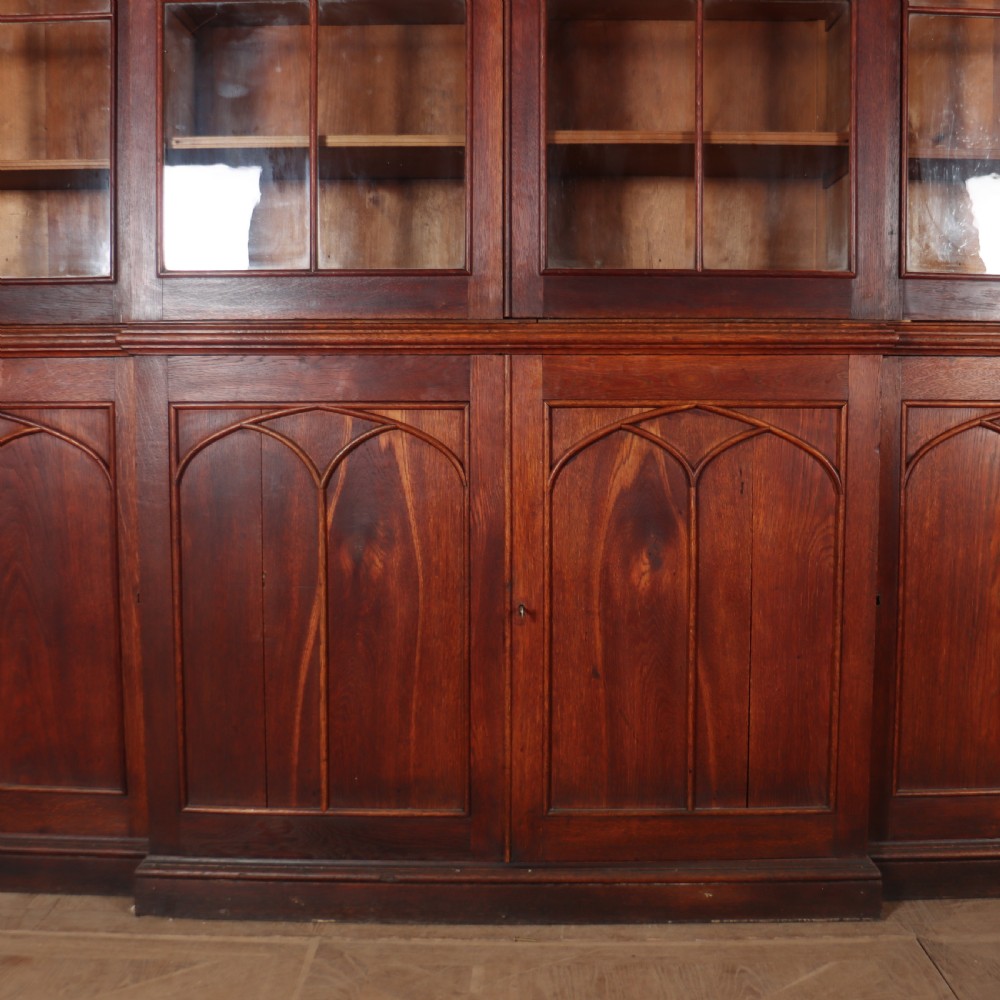 An early 19th-century mahogany breakfront bookcase featuring four glazed doors with Gothic pointed arch tracery over four matching panelled base doors. View III