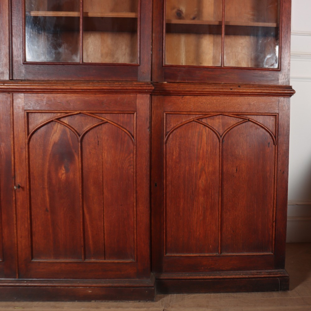 An early 19th-century mahogany breakfront bookcase featuring four glazed doors with Gothic pointed arch tracery over four matching panelled base doors. View V