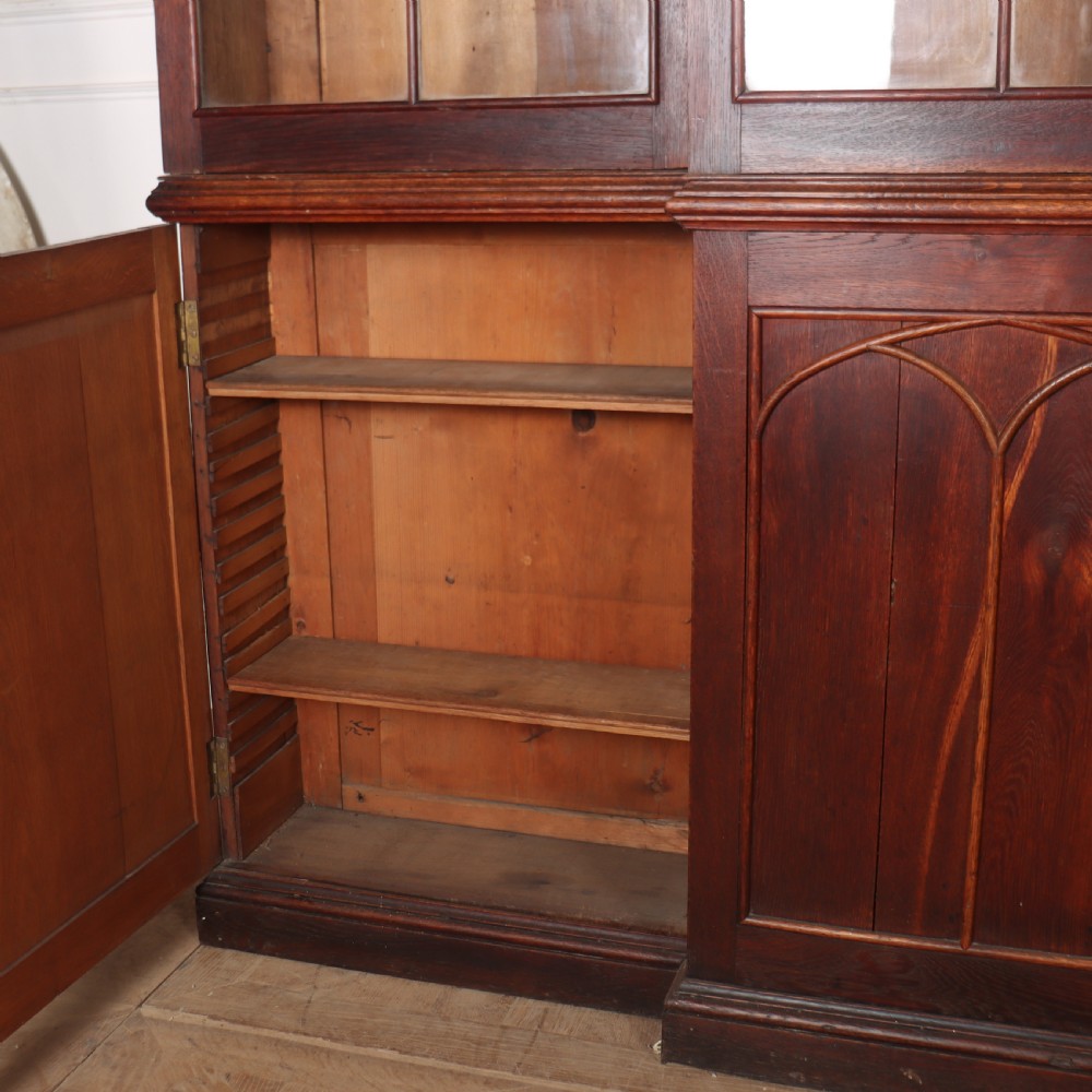 An early 19th-century mahogany breakfront bookcase featuring four glazed doors with Gothic pointed arch tracery over four matching panelled base doors. View IX