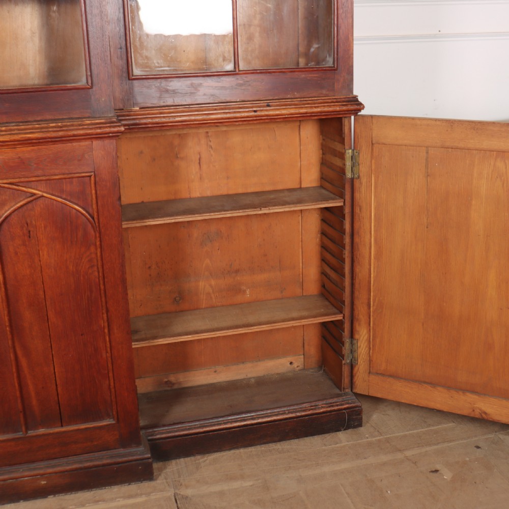 An early 19th-century mahogany breakfront bookcase featuring four glazed doors with Gothic pointed arch tracery over four matching panelled base doors. View XI