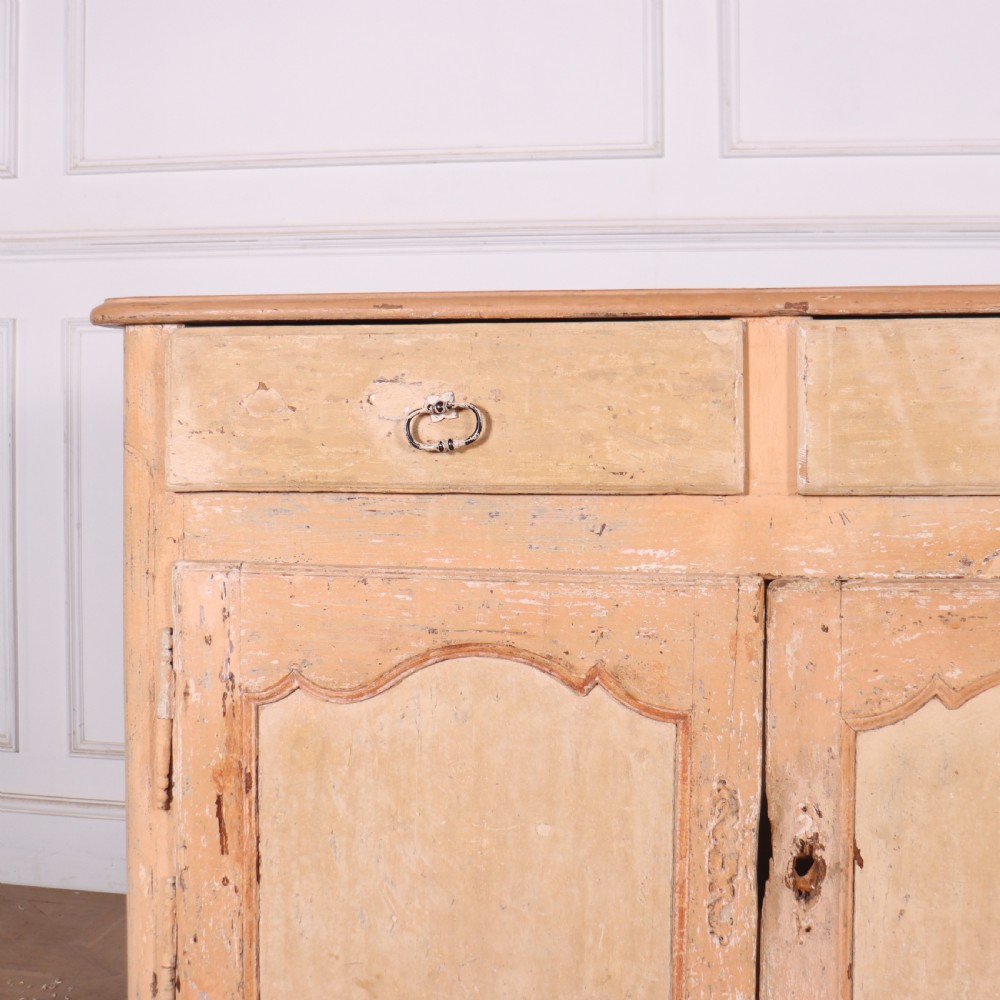 An 18th-century French provincial buffet featuring a distressed beige painted finish, two drawers, two carved panel cupboard doors, and short cabriole legs. View II