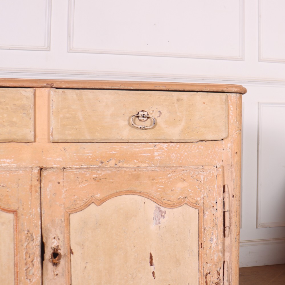 An 18th-century French provincial buffet featuring a distressed beige painted finish, two drawers, two carved panel cupboard doors, and short cabriole legs. View V