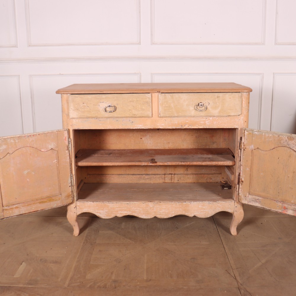 An 18th-century French provincial buffet featuring a distressed beige painted finish, two drawers, two carved panel cupboard doors, and short cabriole legs. View VII