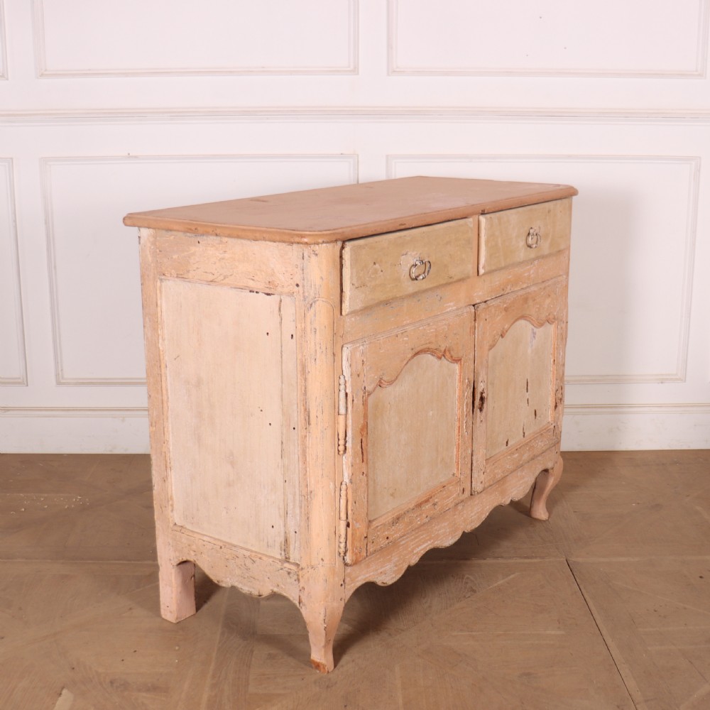 An 18th-century French provincial buffet featuring a distressed beige painted finish, two drawers, two carved panel cupboard doors, and short cabriole legs. View VIII
