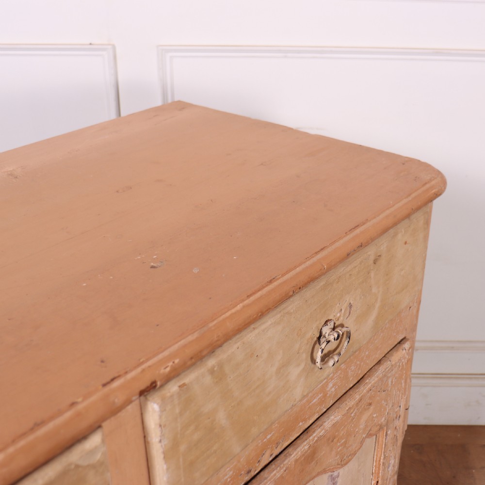An 18th-century French provincial buffet featuring a distressed beige painted finish, two drawers, two carved panel cupboard doors, and short cabriole legs. View X
