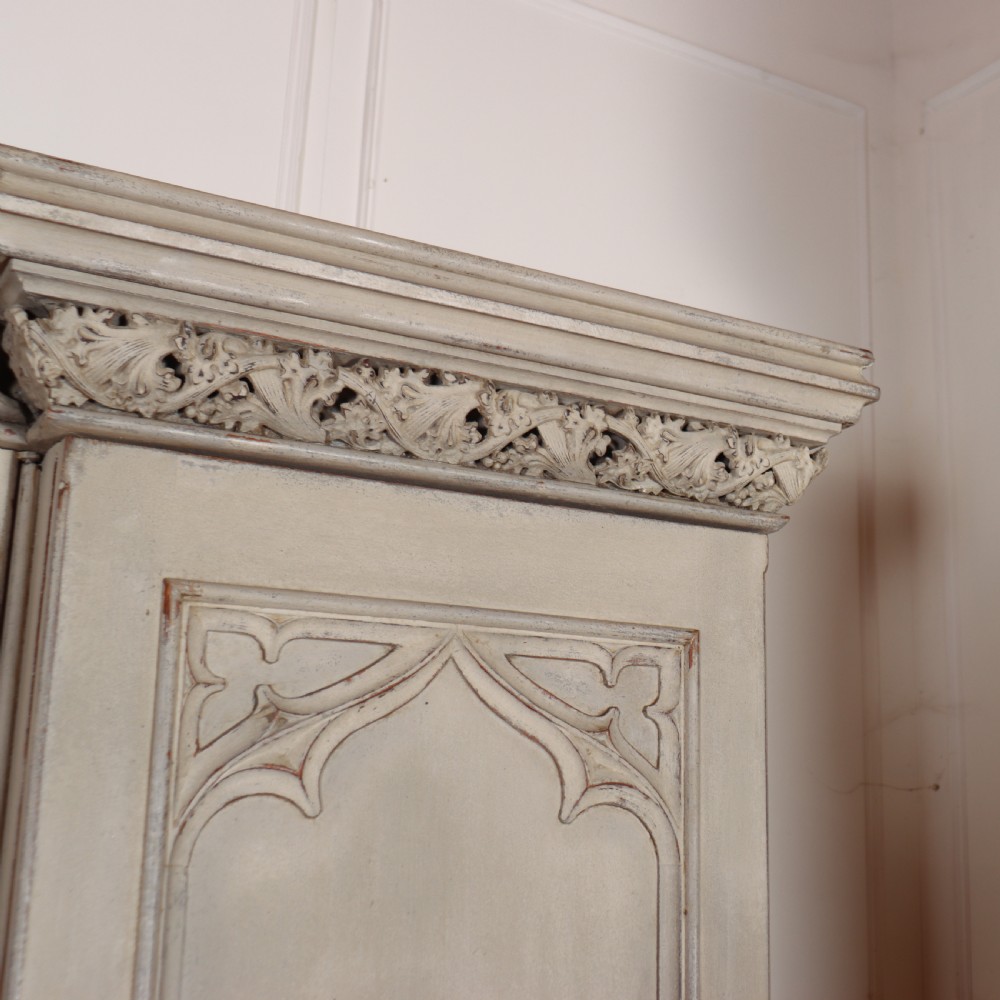A large 19th-century painted wooden three-door wardrobe featuring carved Gothic arches and a detailed crown moulding cornice. View III