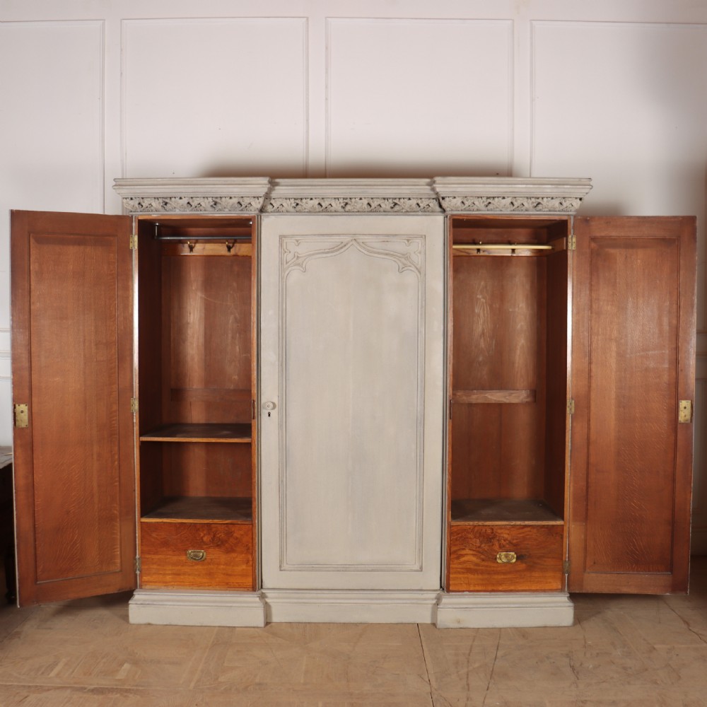 A large 19th-century painted wooden three-door wardrobe featuring carved Gothic arches and a detailed crown moulding cornice. View VII