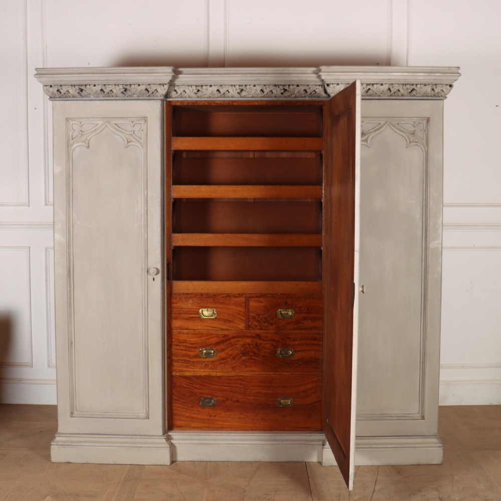 A large 19th-century painted wooden three-door wardrobe featuring carved Gothic arches and a detailed crown moulding cornice. View VIII