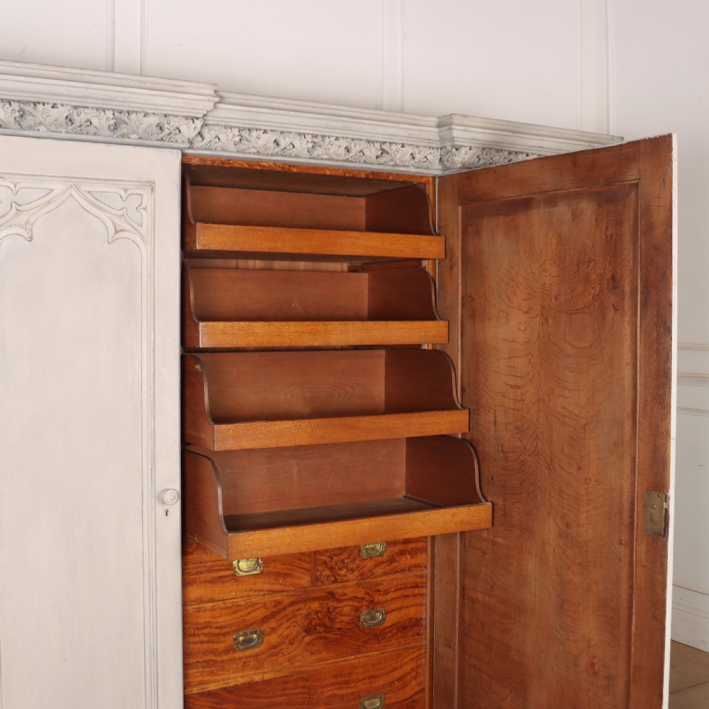 A large 19th-century painted wooden three-door wardrobe featuring carved Gothic arches and a detailed crown moulding cornice. View IX