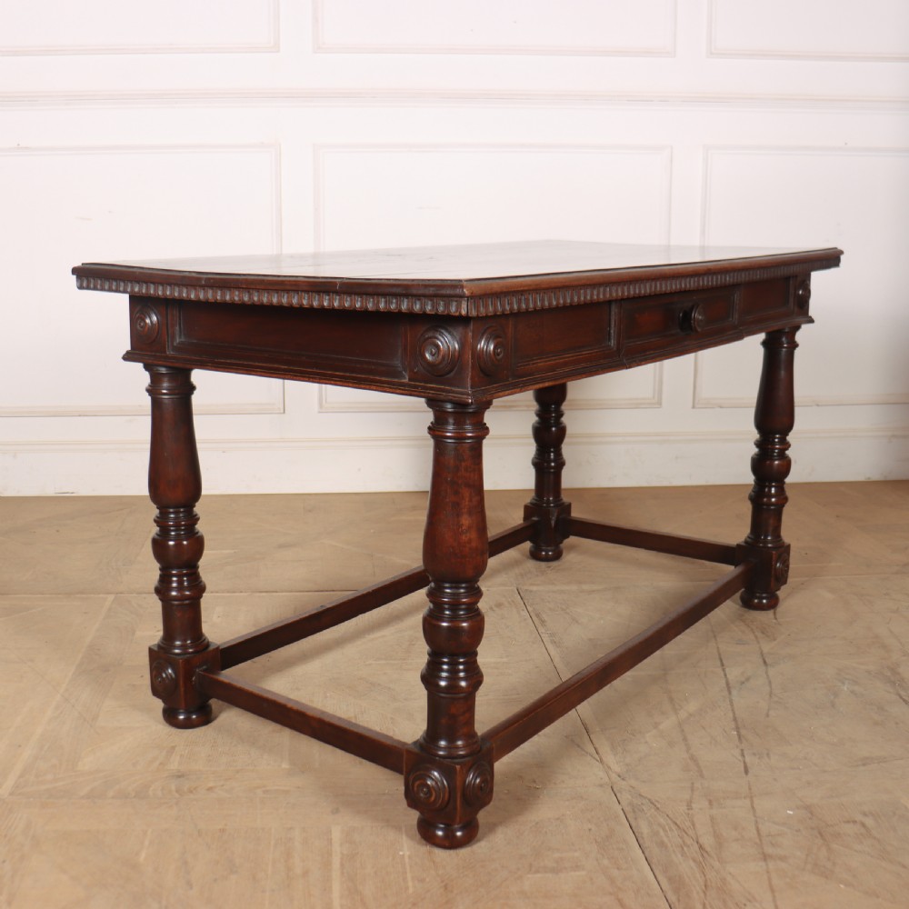 A 19th-century Italian dark walnut writing desk featuring turned legs, a carved frieze, a single central drawer, and a rectangular stretcher base. View VIII