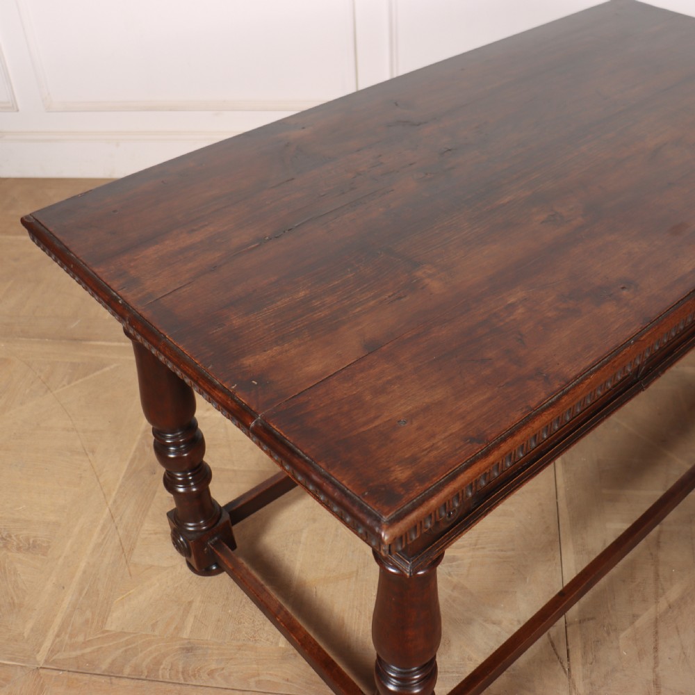 A 19th-century Italian dark walnut writing desk featuring turned legs, a carved frieze, a single central drawer, and a rectangular stretcher base. View IX