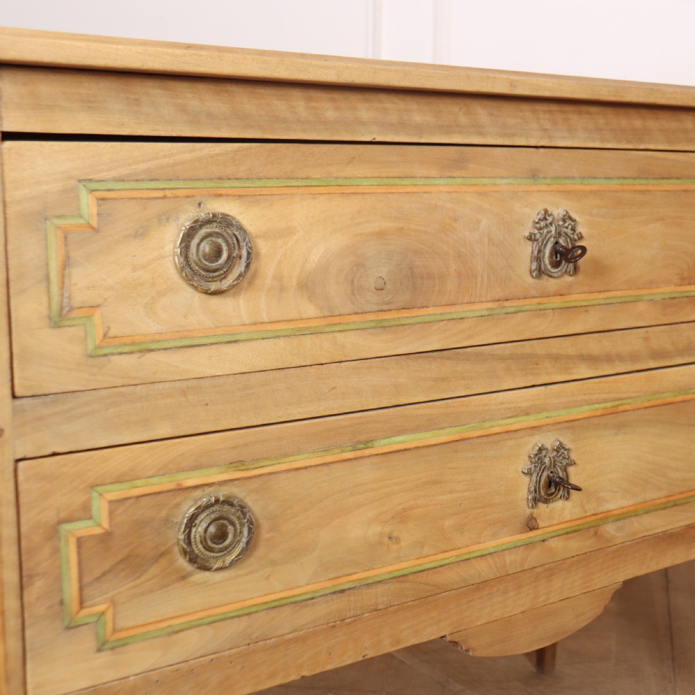 A 19th-century bleached walnut Italian commode featuring two wide drawers with painted border details, circular brass handles, and square tapered legs. View X