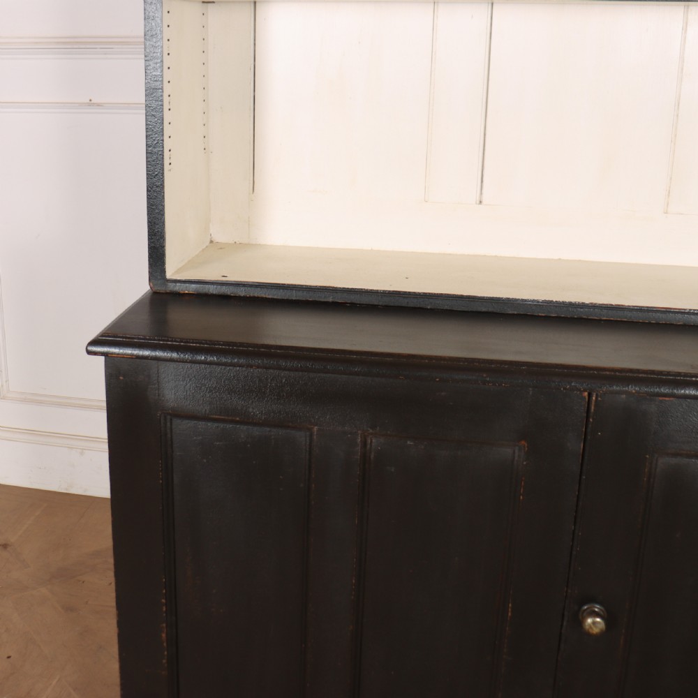 A 19th-century English painted open bookcase featuring a dark exterior, contrasting off-white interior shelves, and a lower two-door cupboard. View VI