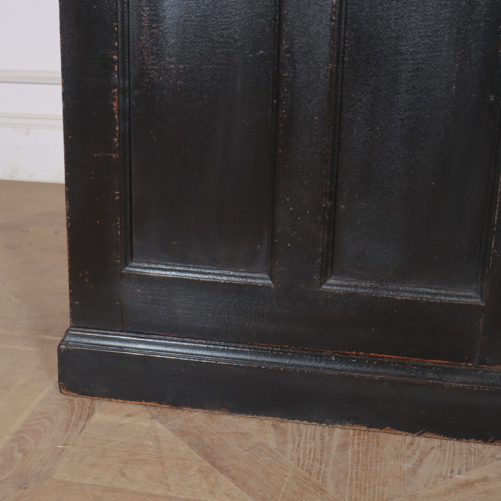 A 19th-century English painted open bookcase featuring a dark exterior, contrasting off-white interior shelves, and a lower two-door cupboard. View VII
