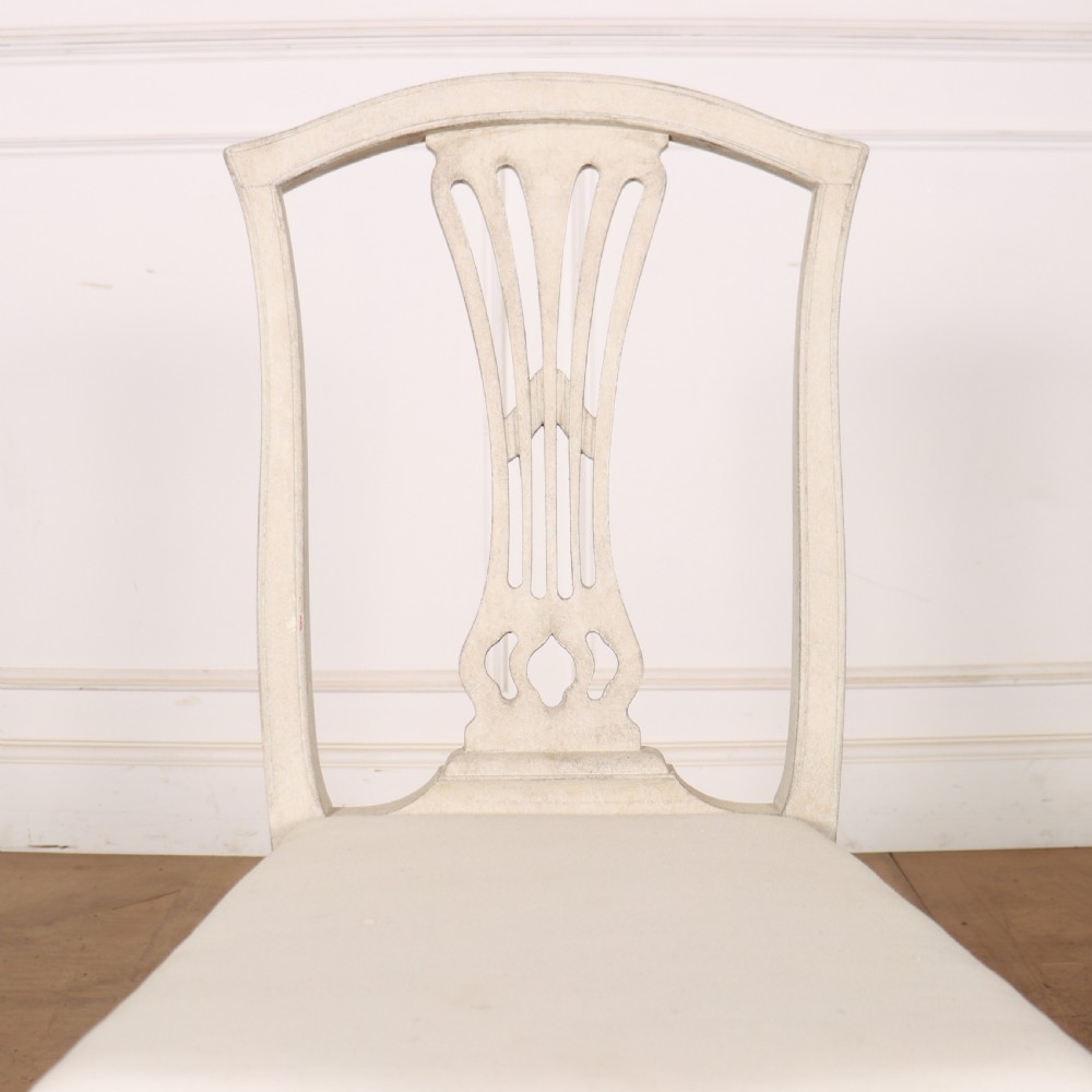 A set of six Gustavian style dining chairs painted in distressed off-white with carved splat backs and white upholstered seats. View XI