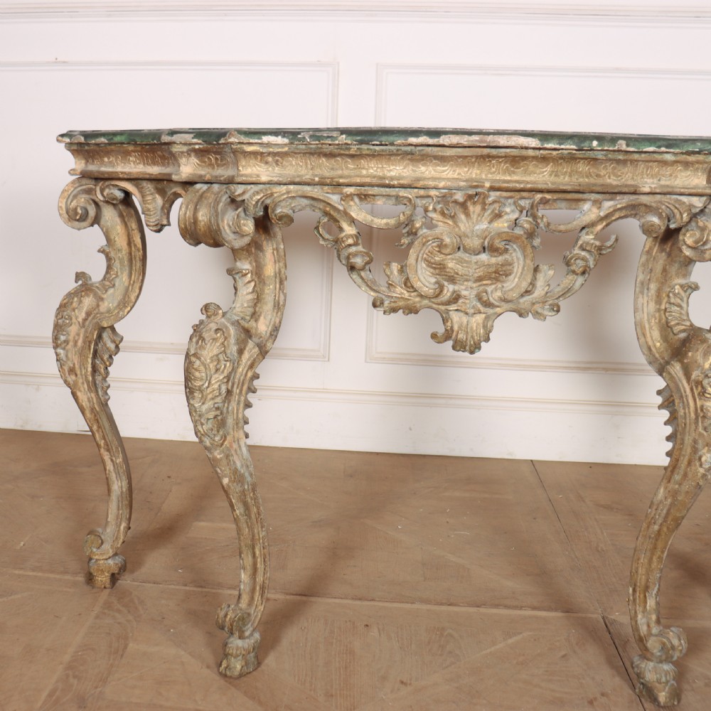 An 18th-century Italian carved giltwood console table featuring scrolled cabriole legs, a rocaille central apron, and a dark green marble top. View II