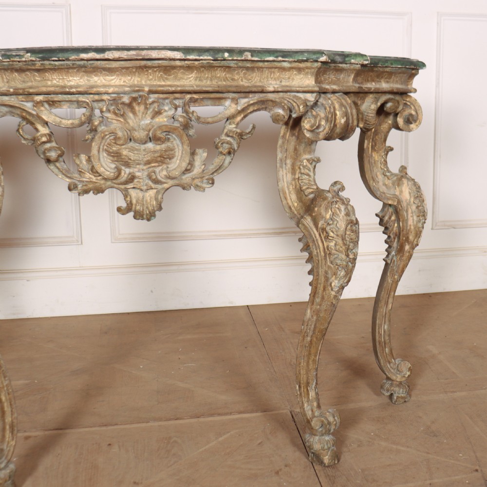An 18th-century Italian carved giltwood console table featuring scrolled cabriole legs, a rocaille central apron, and a dark green marble top. View III
