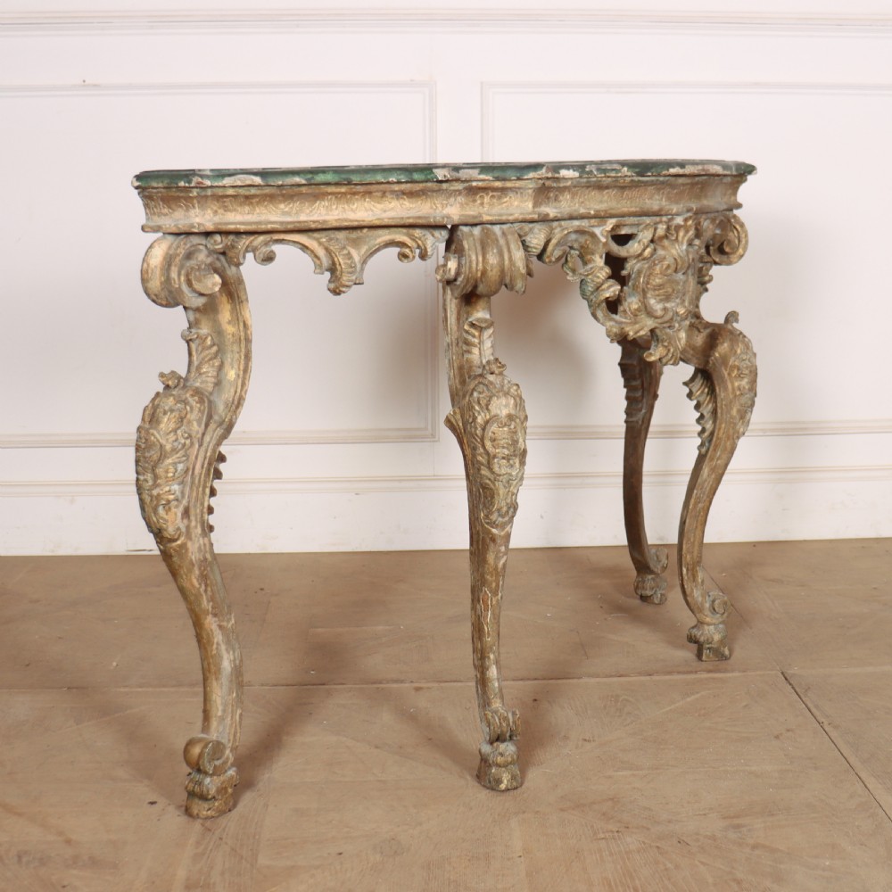 An 18th-century Italian carved giltwood console table featuring scrolled cabriole legs, a rocaille central apron, and a dark green marble top. View V