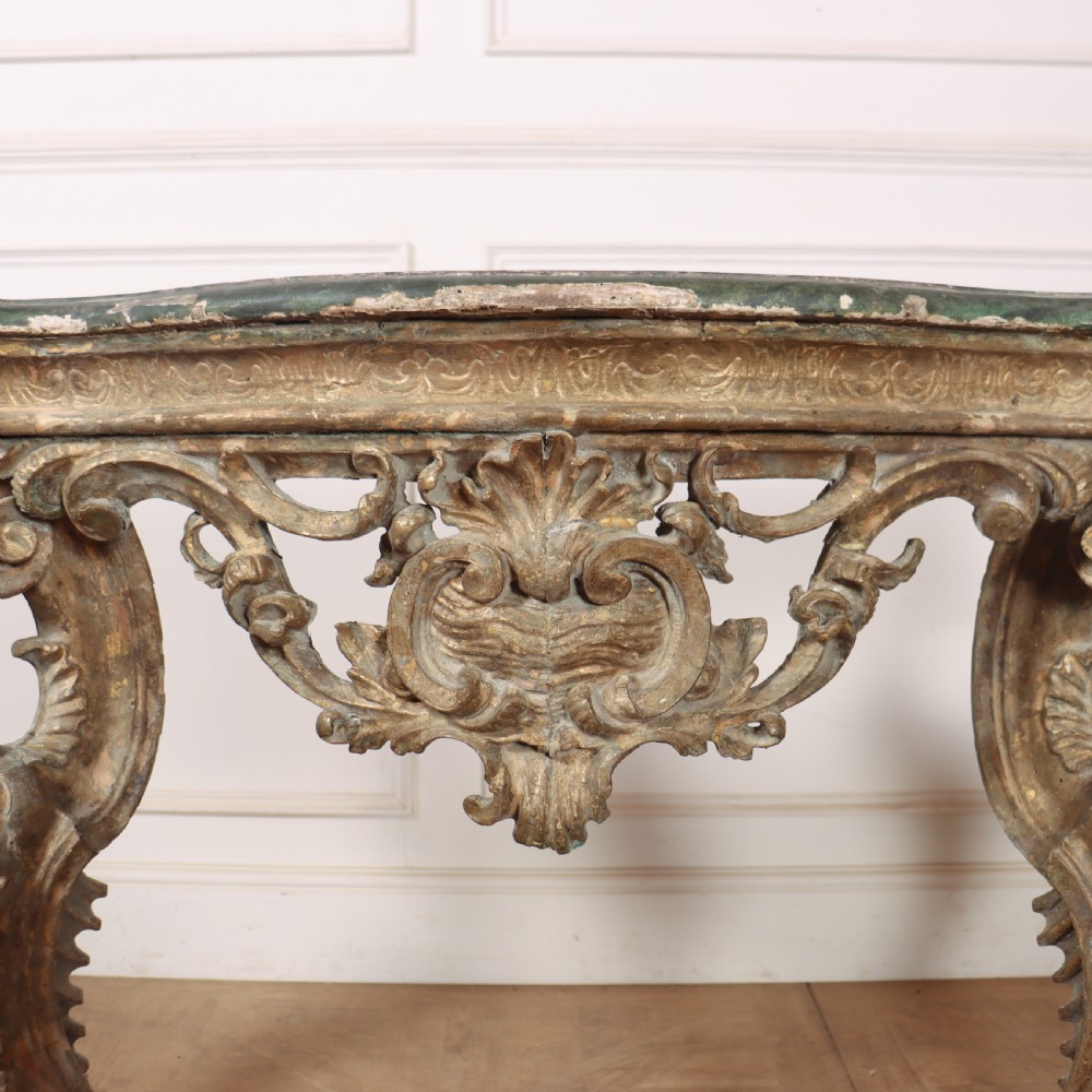 An 18th-century Italian carved giltwood console table featuring scrolled cabriole legs, a rocaille central apron, and a dark green marble top. View XI