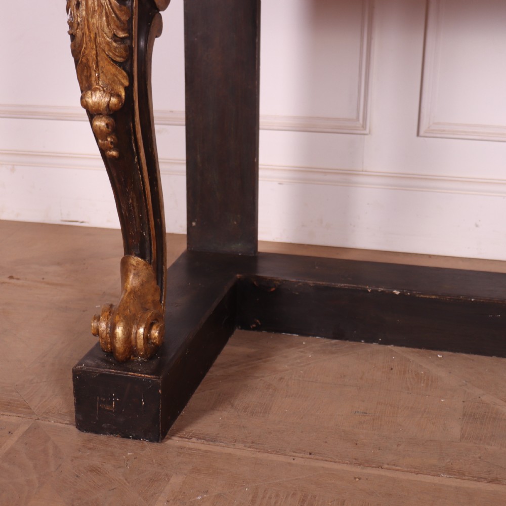 A dark painted and parcel-gilt console table featuring carved acanthus leaf scroll front supports and a flat plinth base. View II