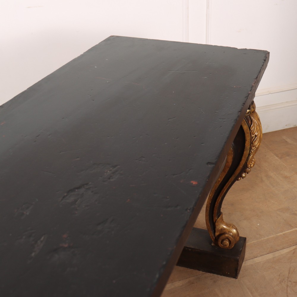 A dark painted and parcel-gilt console table featuring carved acanthus leaf scroll front supports and a flat plinth base. View XI