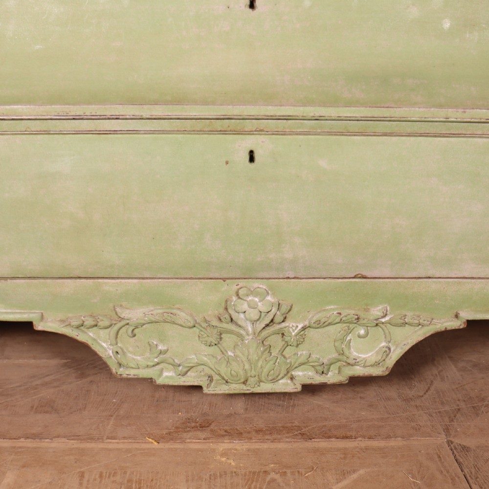 A large sage green painted Dutch linen cupboard featuring a broken pediment cornice, carved swag door panels, brass drop handles, and three lower drawers. View VIII
