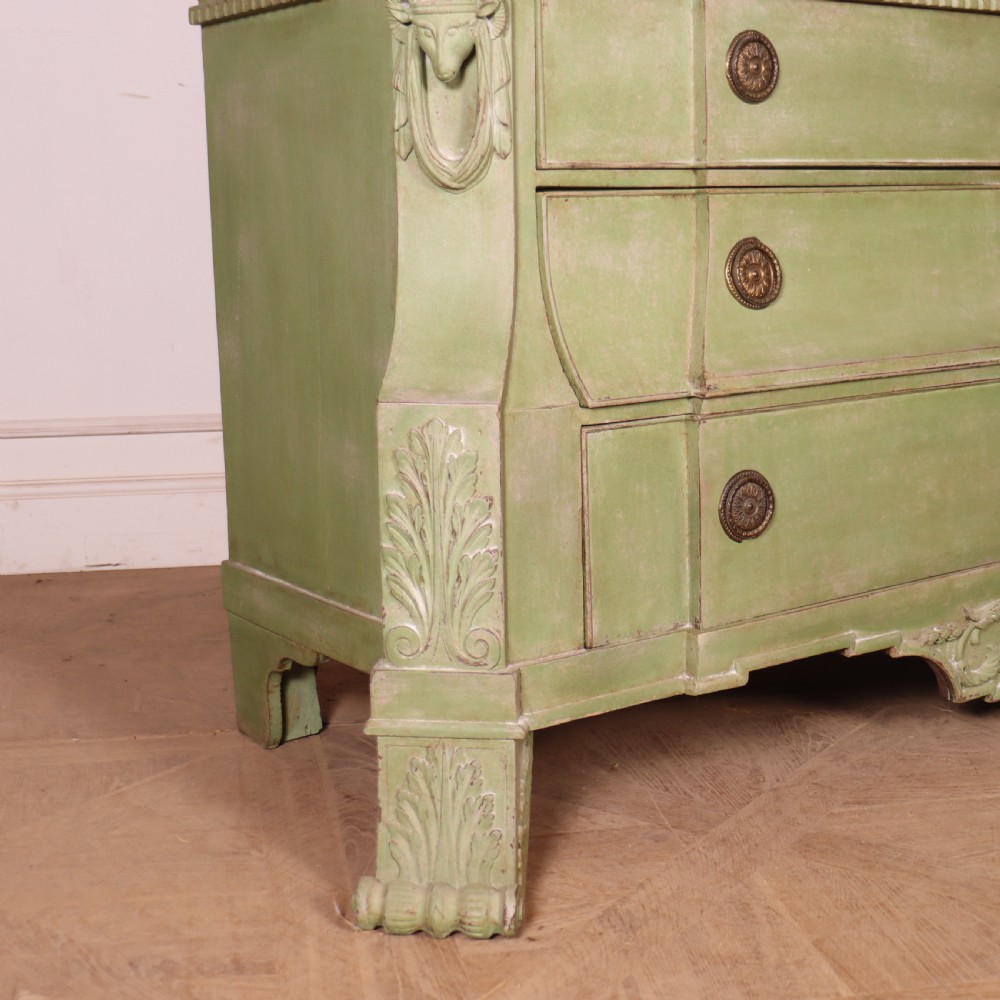 A large sage green painted Dutch linen cupboard featuring a broken pediment cornice, carved swag door panels, brass drop handles, and three lower drawers. View XII