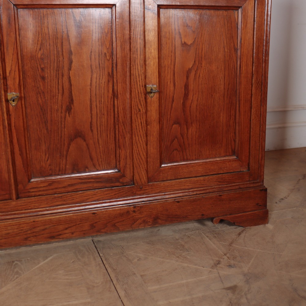 A long French oak enfilade sideboard featuring four field-panel cupboard doors, upper drawers, and central brass key escutcheons. View V