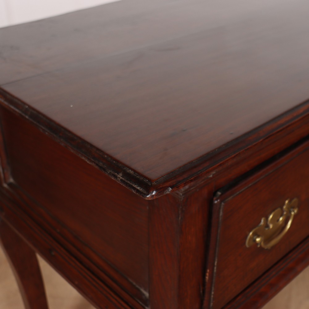 An antique dark oak dresser base featuring three drawers with brass handles and keyhole escutcheons supported on cabriole legs. View IX