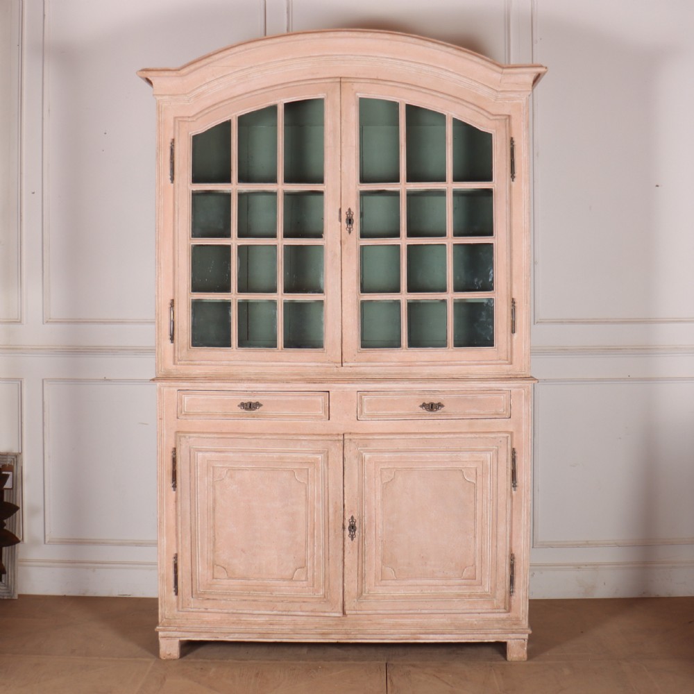 A nineteenth-century French painted glazed dresser featuring arched multi-pane glass doors with a green interior above two drawers and cupboard doors.