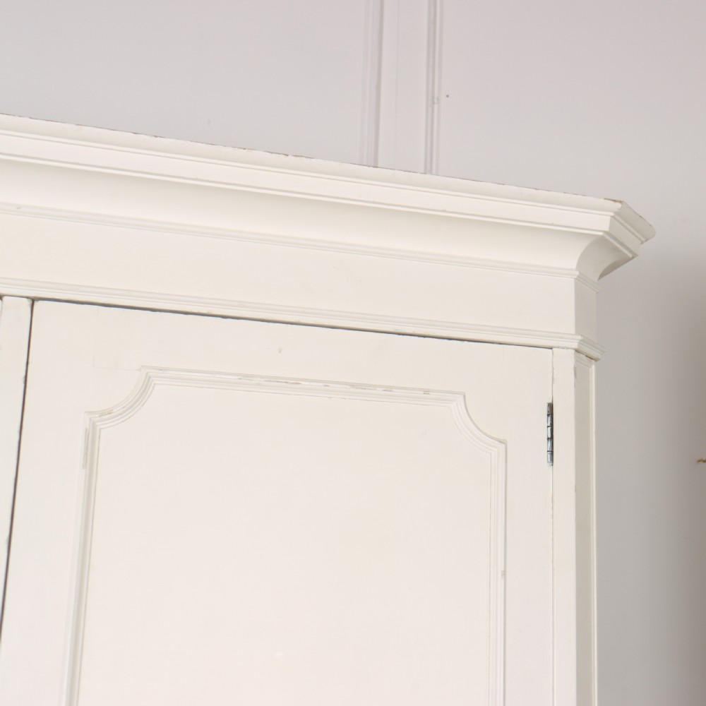 A large 19th-century off-white painted wardrobe featuring three doors, a central arched full-length mirror, moulded cornice, and drop handles. View II