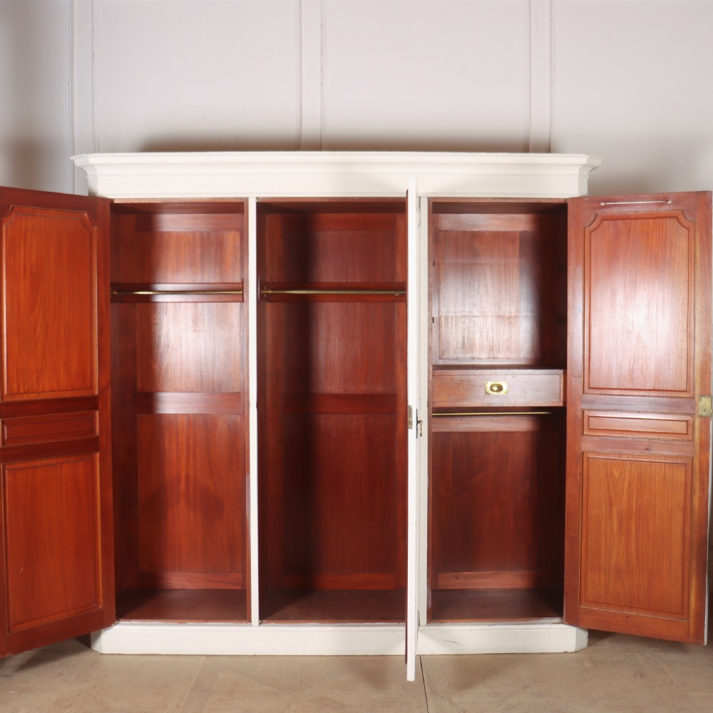 A large 19th-century off-white painted wardrobe featuring three doors, a central arched full-length mirror, moulded cornice, and drop handles. View VI