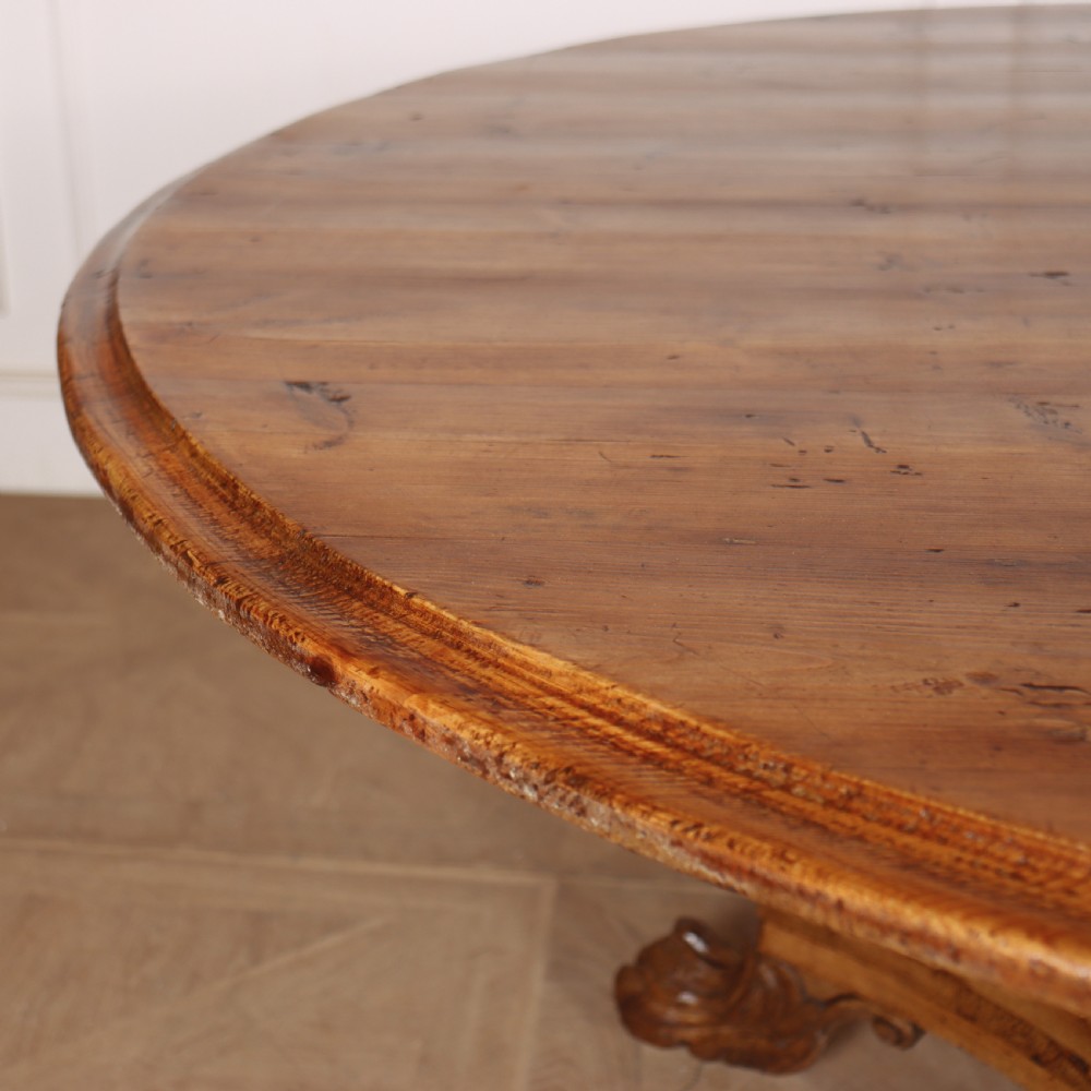 A large 19th-century circular wood supper table featuring a bulbous turned pedestal column and carved paw feet on a triform base. View II