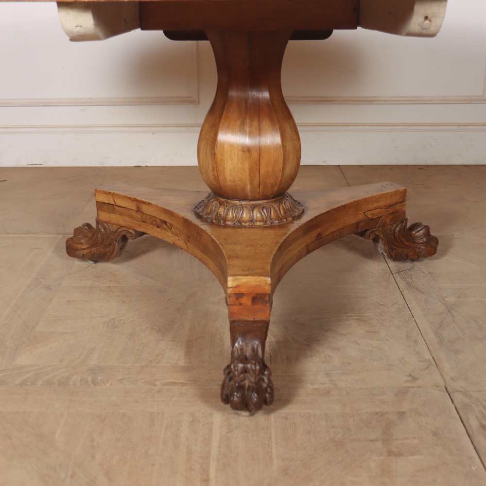 A large 19th-century circular wood supper table featuring a bulbous turned pedestal column and carved paw feet on a triform base. View III