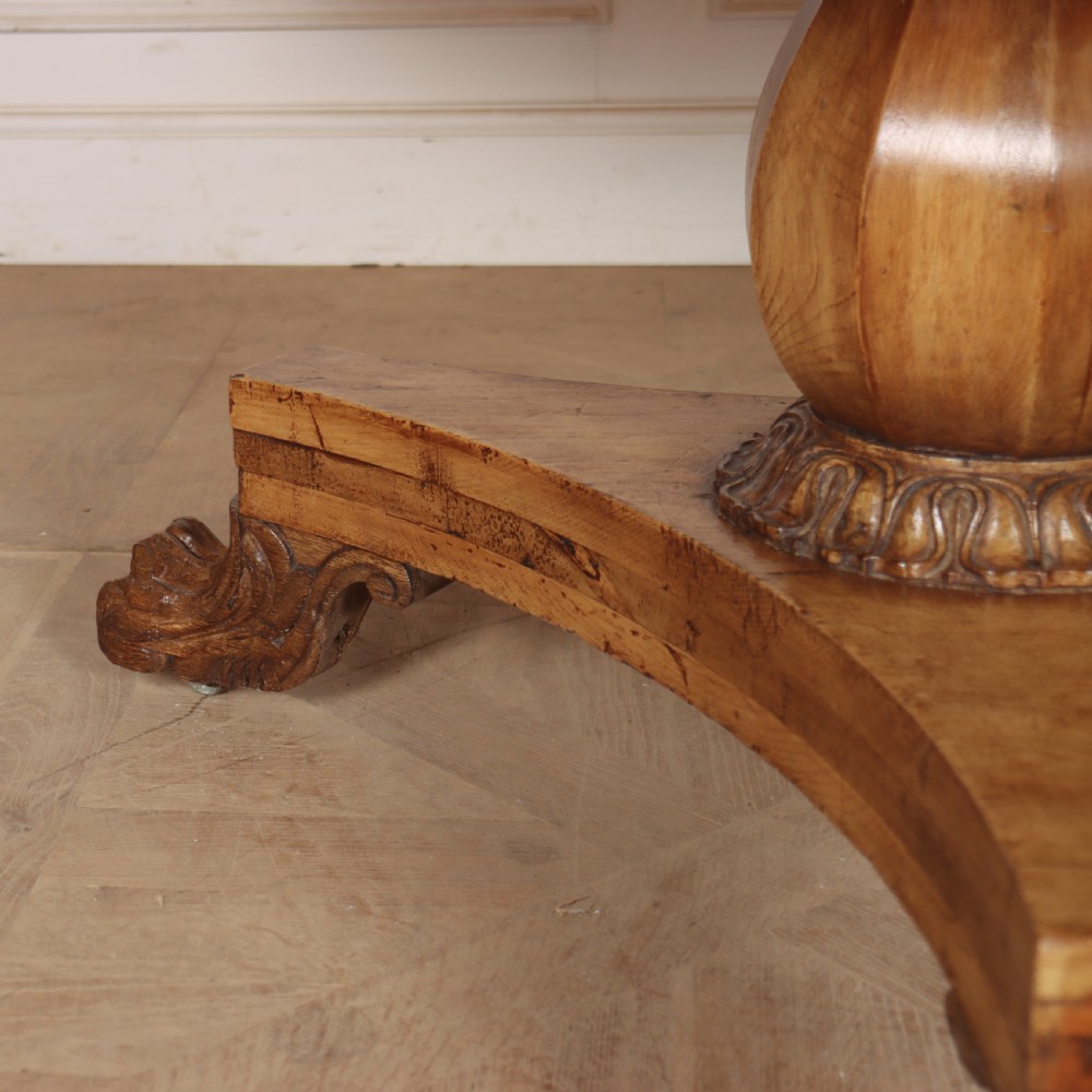 A large 19th-century circular wood supper table featuring a bulbous turned pedestal column and carved paw feet on a triform base. View V