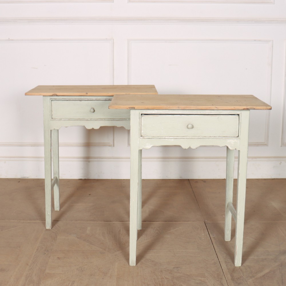 A pair of 19th-century English side tables featuring natural pine tops, single frieze drawers, and pale green painted bases with square tapered legs.