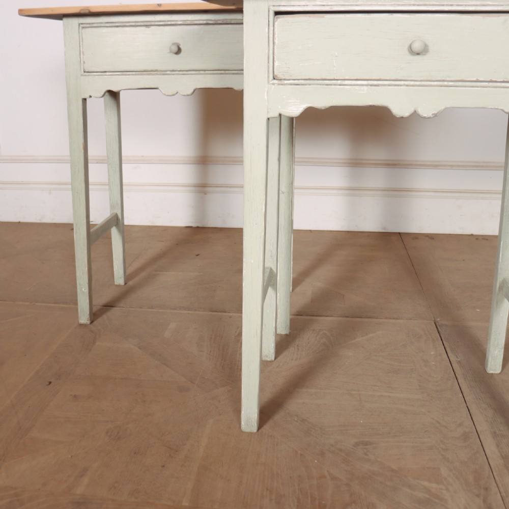 A pair of 19th-century English side tables featuring natural pine tops, single frieze drawers, and pale green painted bases with square tapered legs. View VI
