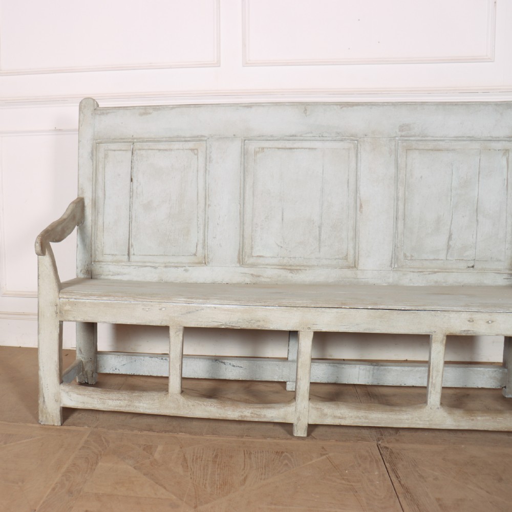 An 18th-century painted wooden tavern bench featuring a high back with three recessed panels, curved armrests, and lower stretchers. View II